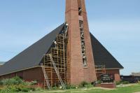 RSI-Roofing Services, Inc. crew installing new black shingles on a church